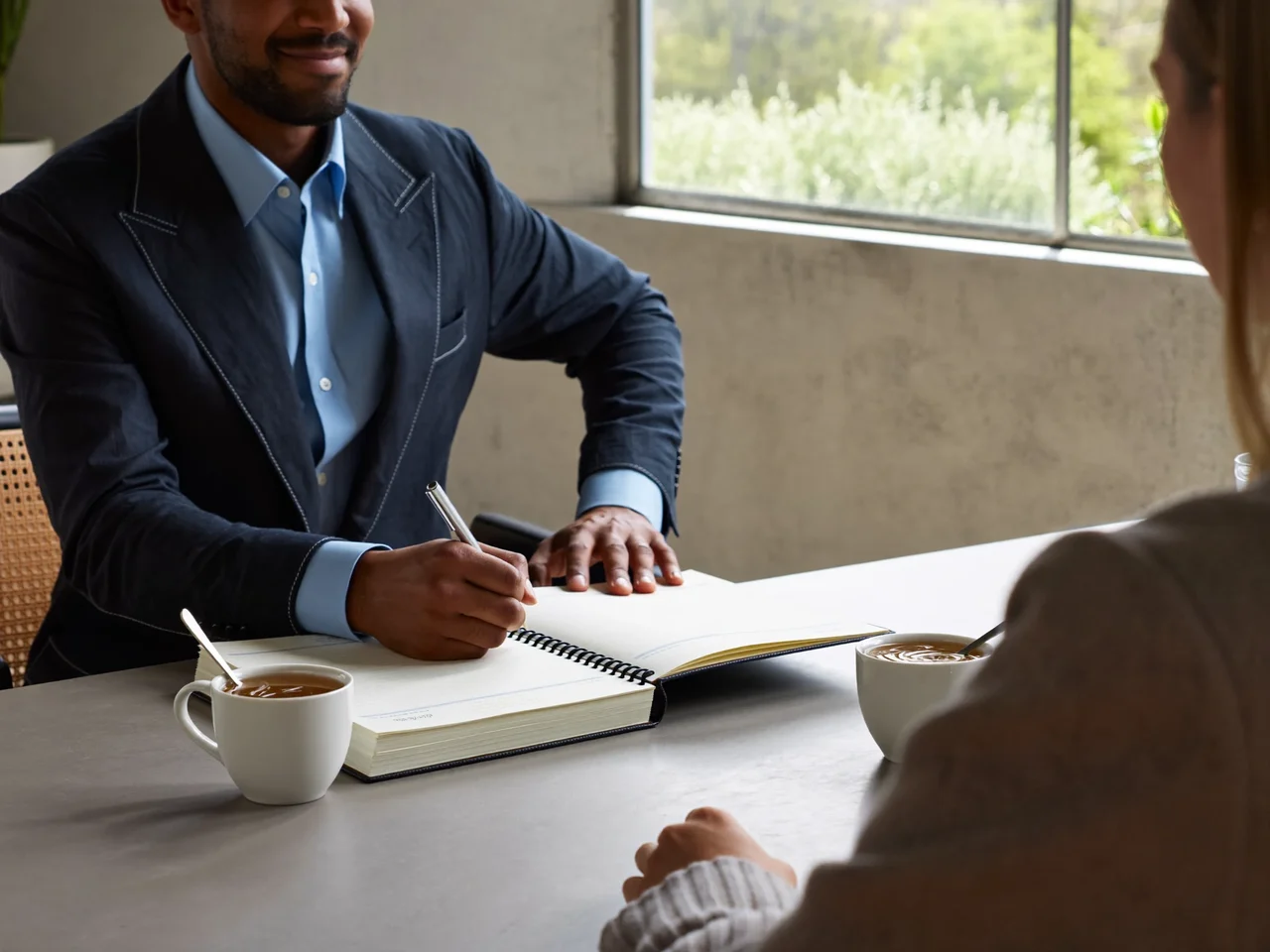 Illustration of an adviser and resident in a friendly one-to-one meeting with tea and notes