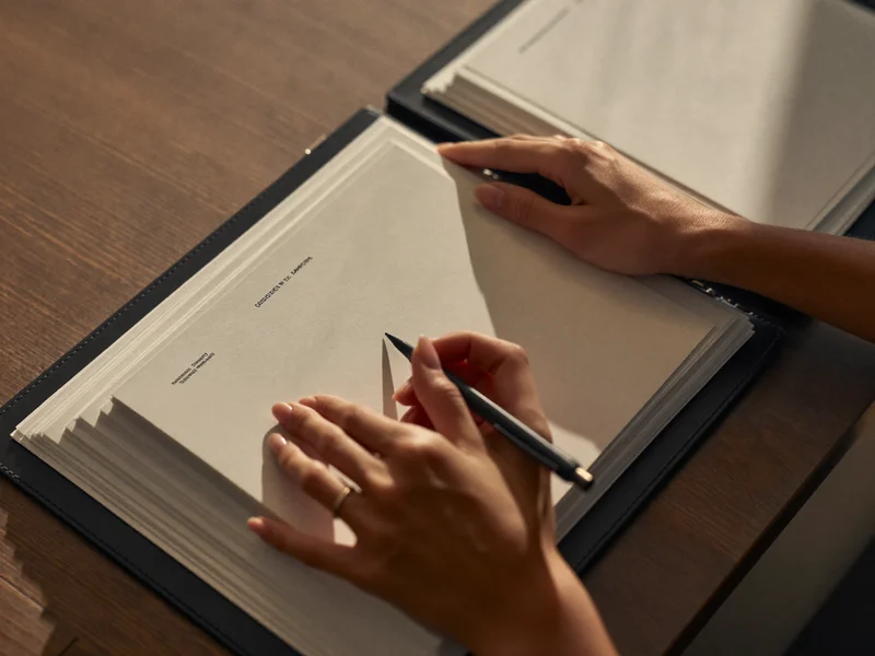 Illustration of hands filling in a blank paper form beside a folder of documents
