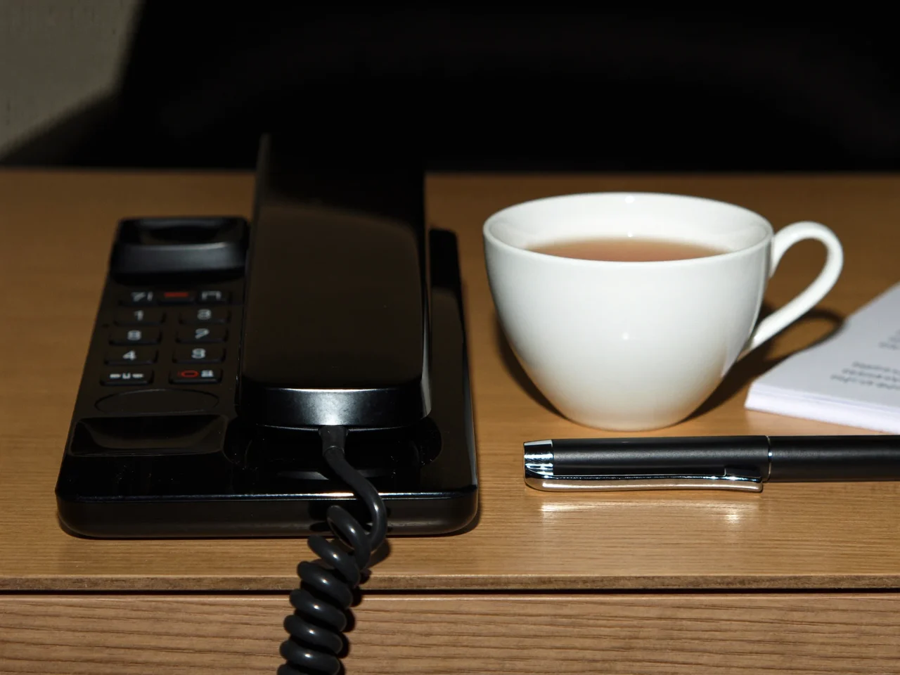 Illustration of a phone handset, notepad and tea cup ready for a telephone advice session