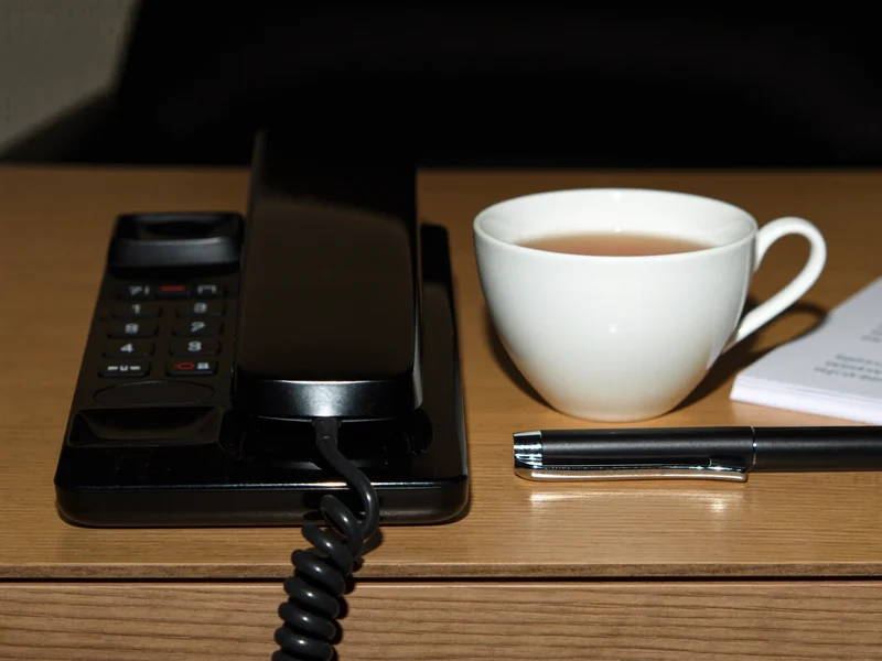 Illustration of a phone handset, notepad and tea cup ready for a telephone advice session